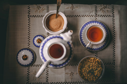 Rooibos tea in a tea pot and cup with sugar and spices