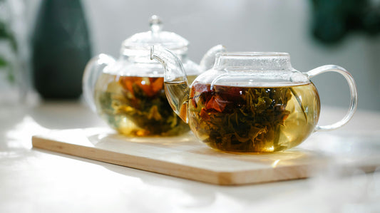 Glass teapots with herbs steeping for a herbal tea