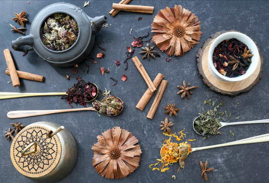 Chai tea in a tea cup and tea mug, with ingredients and spices like cinnamon, gloves, garlic, anise, turmeric, cardamom