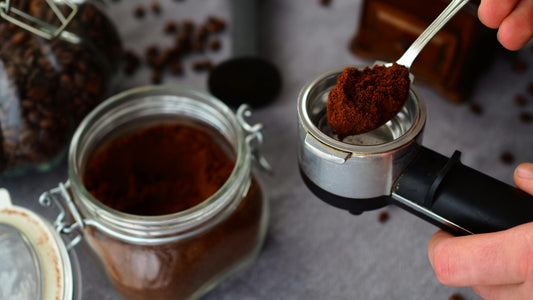 Ground coffee beans from a coffee grinding tool about to be placed into an air tight jar for storage