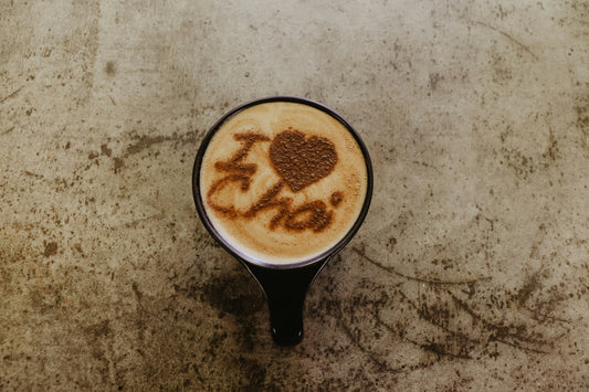 Chai tea latte with latte art spelling out "I Love Chai" with a heart