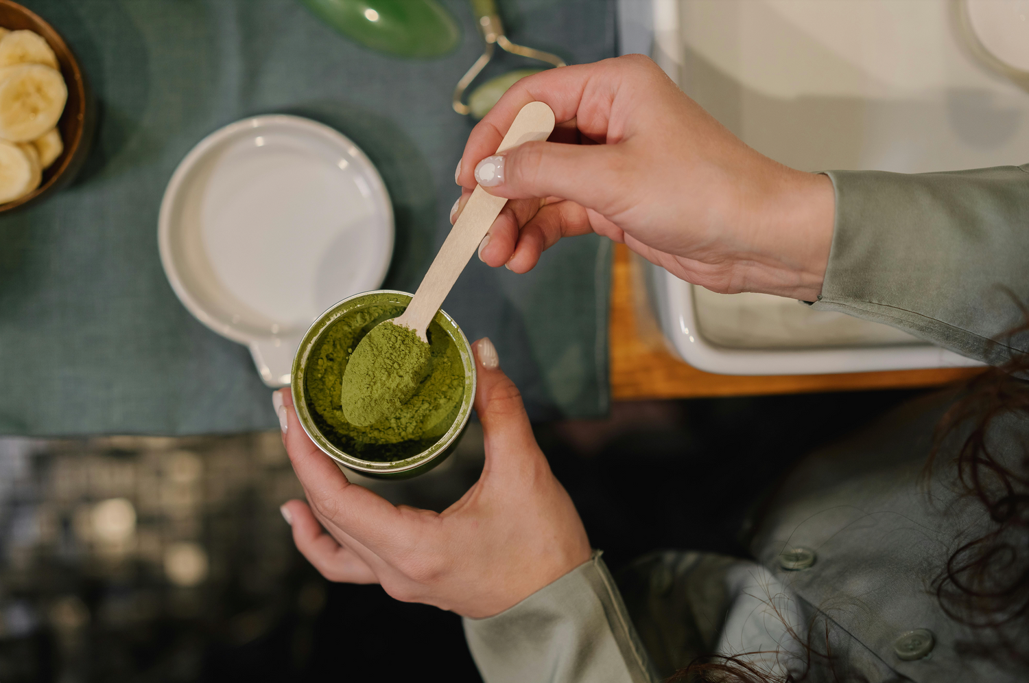 Micground matcha green tea powder on a spoon about to be placed into a mug