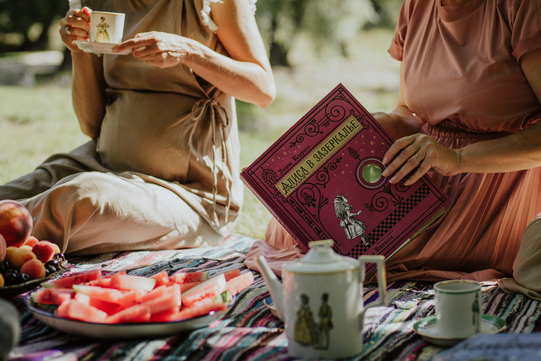 A pregnant lady holding a cup of rooibos chai tea. Sitting at a picnic